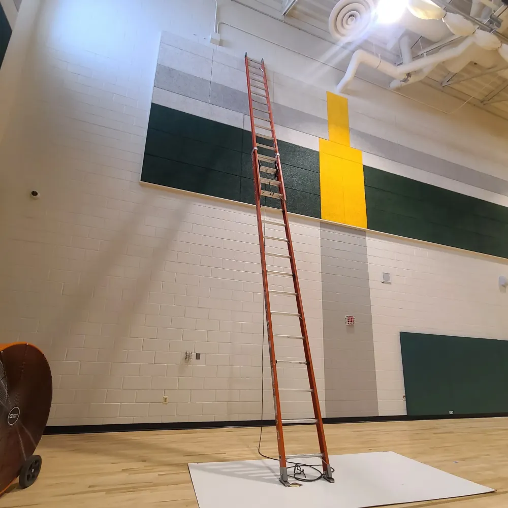 Gaithersburg middle school gym walls painted white with special design in middle of various colors.