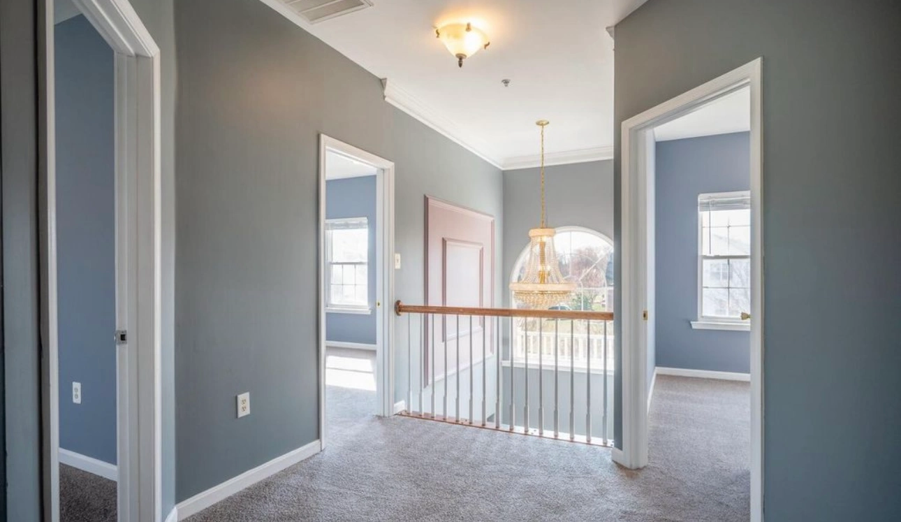 Upstairs hallway of residential home with white walls and ceiling.